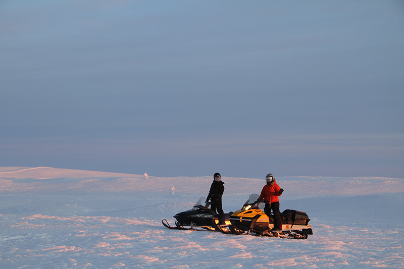 Snowmobiles crossing the open snowy tundra