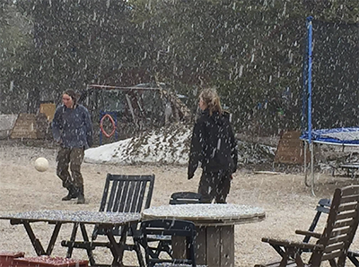 Staff team playing snow football at a picnic