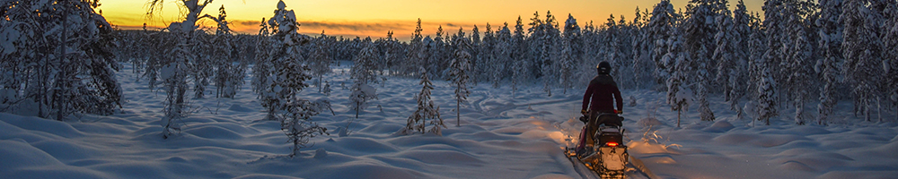 Snowmobile overnight tour at sunset in the spring wilderness